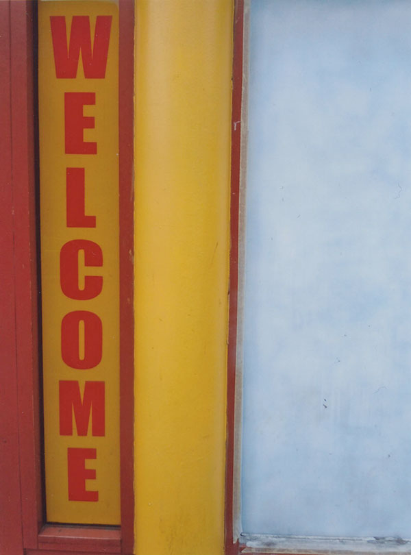 Photograph of a red and yellow WELCOME sign